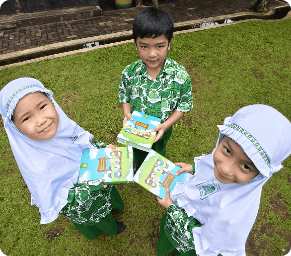 Siswa TKIT berbagi buku cerita di halaman sekolah