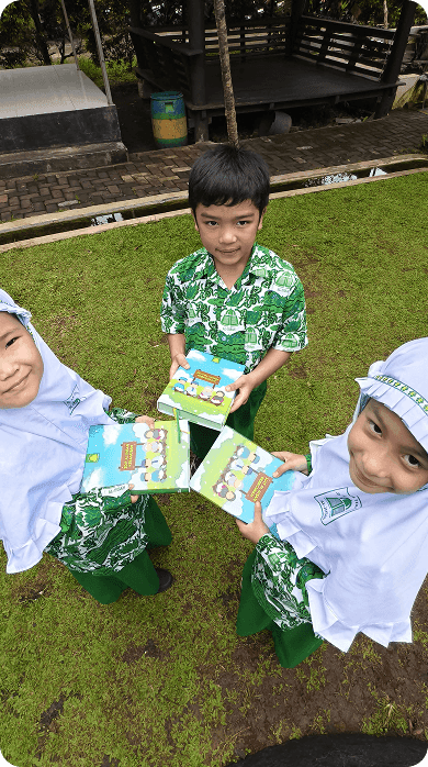Siswa TKIT berbagi buku cerita di halaman sekolah
